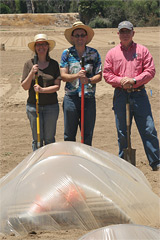 Graduate student Kris Weathers (left), CE specialist and plant physiologist Milt McGiffin, and principal investigator Carl Bell examine a small mock-up of a solar tent