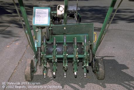 The metal tubes of this roller type aerifier remove soil cores from a lawn. 