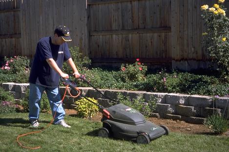 Mowing a lawn with an electric mulching mower.  