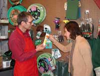 Retail nursery employee and customer look at a tube of tanglefoot.