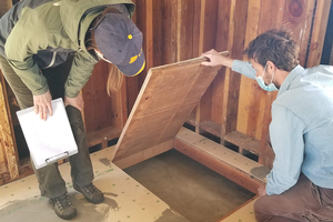 University of California Agriculture and Natural Resources Staff Research Assistant Casey Hubble and Richmond Field Station Maintenance & Operations Director Justin Cocke examine removable floor panels that were installed to provide access to the unique hybrid foundation under the <i>Villa Termiti</i>: a combination quasi-slab and perimeter wall raised concrete foundation. Credit: Andrew Sutherland, UC IPM. Copyright 2021 Regents of the University of California. Photo by: Andrew M. Sutherland, UC IPM. Copyright 2021 Regents of the University of California.